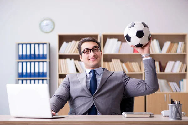 Empresário com bola de futebol no escritório — Fotografia de Stock