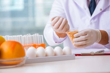 Besin uzmanı gıda ürünlerini laboratuarda test ediyor.