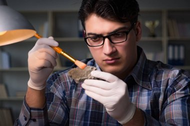 Arkeolog geç saatlere kadar ofiste çalışıyor.