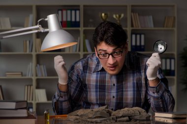 Arkeolog geç saatlere kadar ofiste çalışıyor.