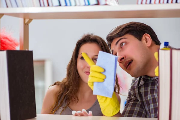 Wife and husband cleaning dust from bookshelf — Stock Photo, Image
