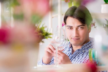 Genç yakışıklı dükkândan alışveriş yapıyor.