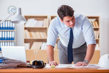 Ofiste çizimler üzerinde çalışan bir mühendis.