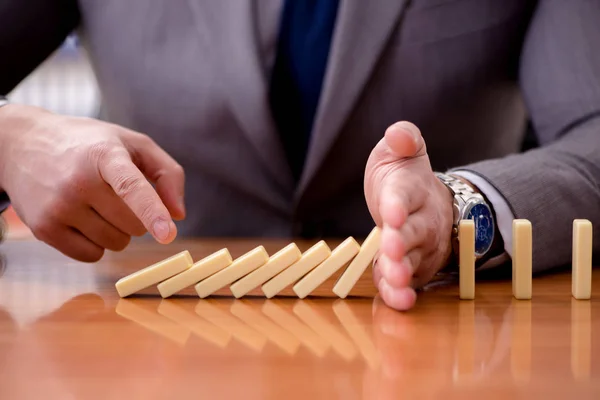 Affärsman med domino på kontoret — Stockfoto