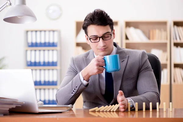 Бизнесмен с домино в офисе — стоковое фото