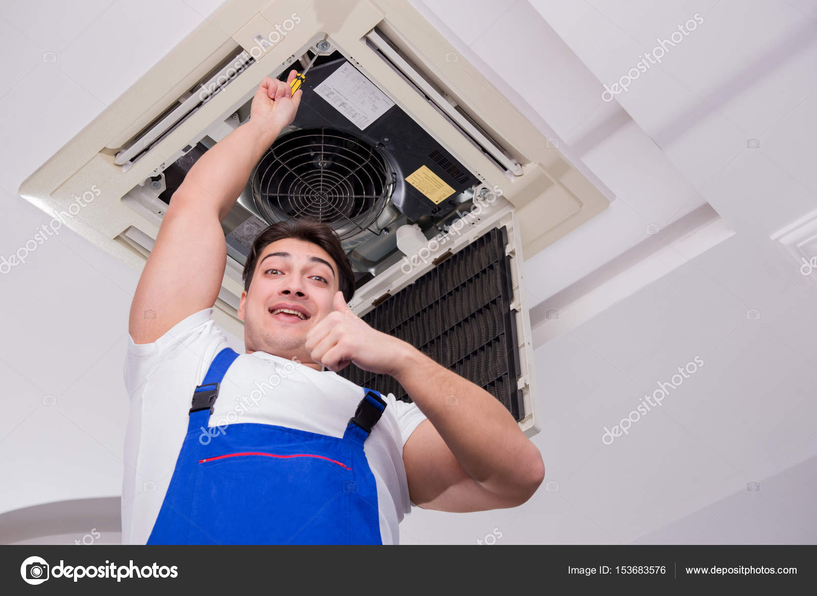 Worker Repairing Ceiling Air Conditioning Unit Stock Photo