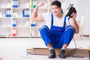 Zemin kaplamalarında çalışan genç bir işçi.