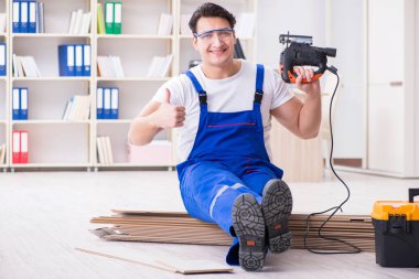 Zemin kaplamalarında çalışan genç bir işçi.