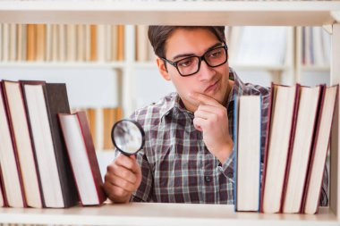 Üniversite kütüphanesinde kitap arayan genç bir öğrenci.