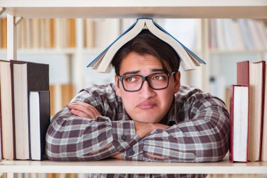 Üniversite kütüphanesinde kitap arayan genç bir öğrenci.