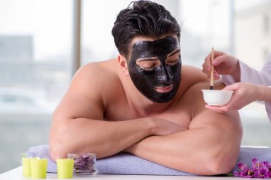 Kaplıca masaj konseptinde yakışıklı bir adam.