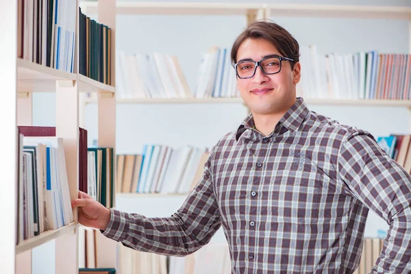 Молодий студент шукає книги в бібліотеці коледжу — стокове фото