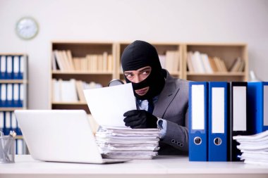 Suçlu iş adamı ofiste kar maskesi giyiyor.