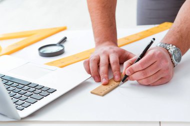 Erkek mühendis çizimler ve planlar üzerinde çalışıyor.