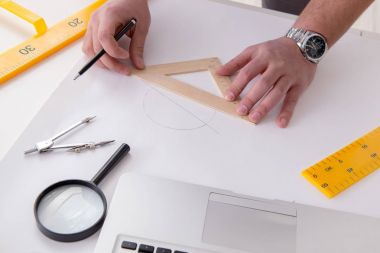 Erkek mühendis çizimler ve planlar üzerinde çalışıyor.