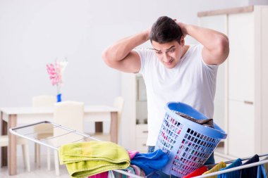 Adam evde çamaşır yıkıyor.