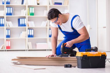 Zemin kaplamalarında çalışan genç bir işçi.