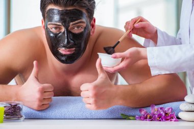 Kaplıca masaj konseptinde yakışıklı bir adam.