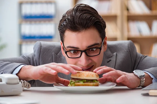 Hambriento empresario divertido comer sándwich de comida chatarra —  Fotos de Stock