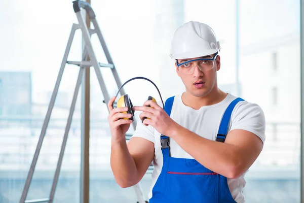 Junger Arbeiter mit lärmintensiven Kopfhörern — Stockfoto