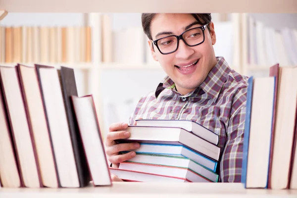 Joven estudiante en busca de libros en la biblioteca universitaria — Foto de Stock