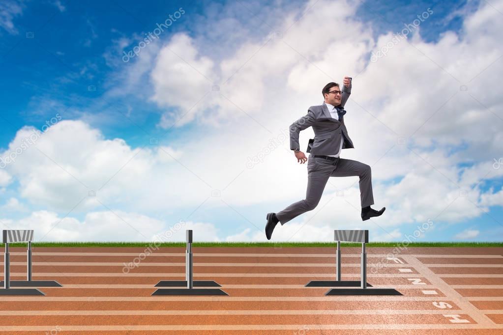 Businessman jumping over barriers in business concept