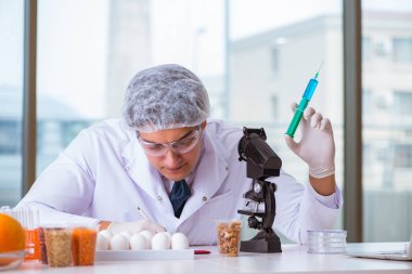 Besin uzmanı gıda ürünlerini laboratuarda test ediyor.