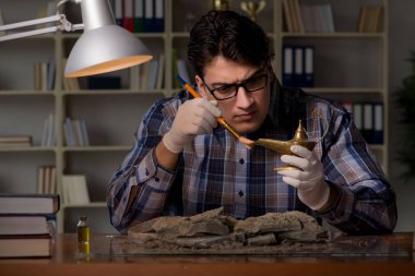 Arkeolog geç saatlere kadar ofiste çalışıyor.