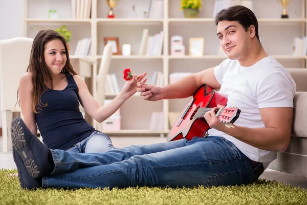 Romantische paar gitaarspelen op verdieping — Stockfoto