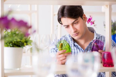 Genç yakışıklı dükkândan alışveriş yapıyor.