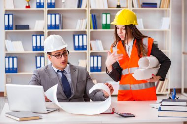 İnşaat ustabaşı çizimleri gözden geçiriyor