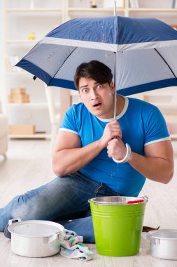 Evdeki adam, komşu sel sızıntısıyla uğraşıyor.