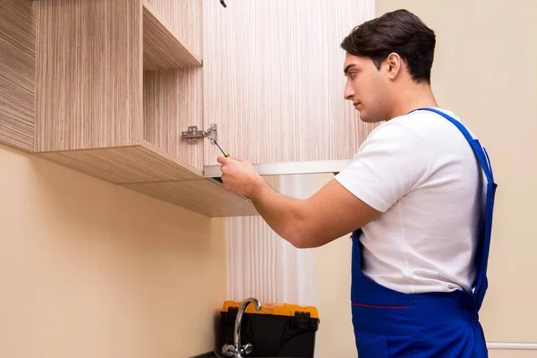 Joven ensamblando muebles de cocina —  Fotos de Stock