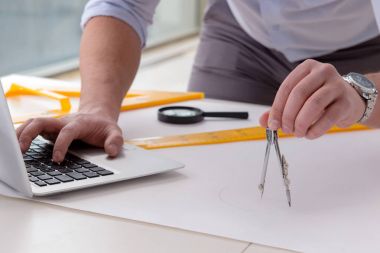 Erkek mühendis çizimler ve planlar üzerinde çalışıyor.