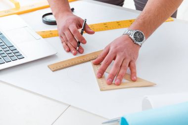 Erkek mühendis çizimler ve planlar üzerinde çalışıyor.