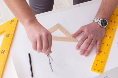 Erkek mühendis çizimler ve planlar üzerinde çalışıyor.