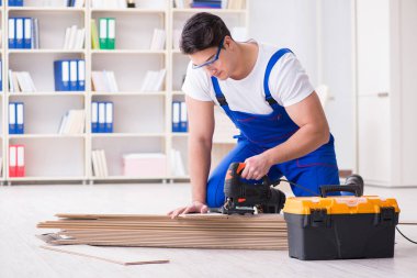 Zemin kaplamalarında çalışan genç bir işçi.