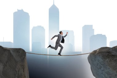 İş adamı iş konseptinde sıkı bir ipin üzerinde yürüyor