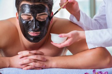 Kaplıca masaj konseptinde yakışıklı bir adam.