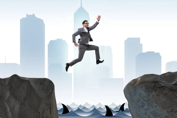Ambitious businessman jumping over the cliff — Stock Photo, Image