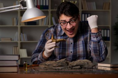 Arkeolog geç saatlere kadar ofiste çalışıyor.