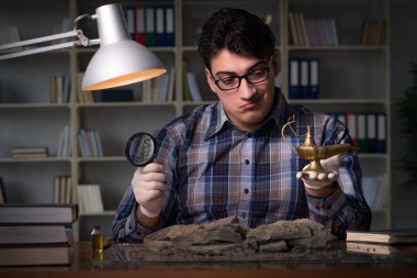 Arkeolog geç saatlere kadar ofiste çalışıyor.