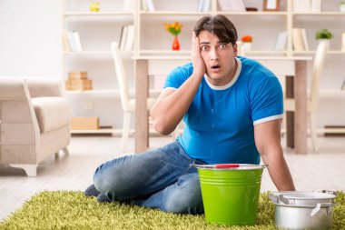 Evdeki adam, komşu sel sızıntısıyla uğraşıyor.