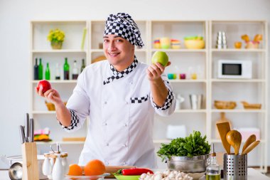 Genç aşçı mutfakta çalışıyor.