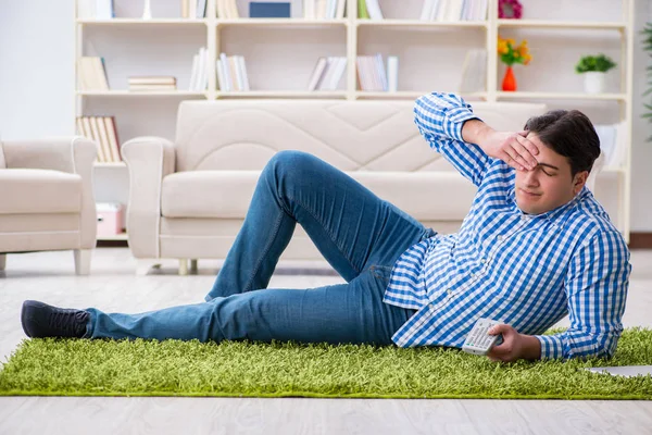 Jonge knappe man zit op de vloer thuis — Stockfoto