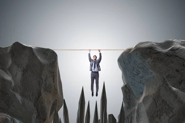 Businessman hanging on rope in danger concept — Stock Photo, Image