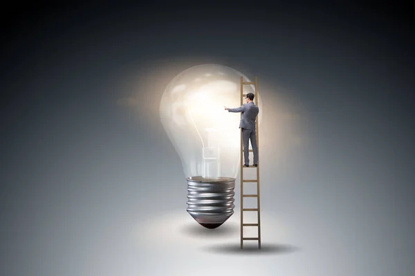 Businessman on ladder with light bulb — Stock Photo, Image