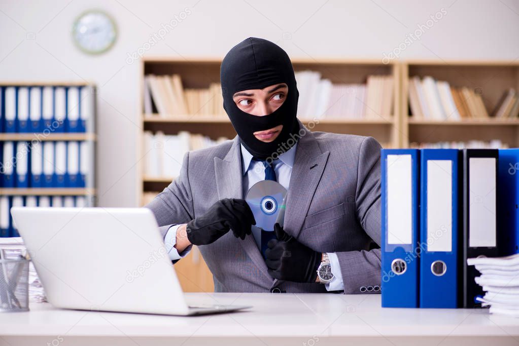 Criminal businessman with balaclava in office