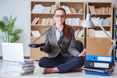 İş kadını ofiste meditasyon yapıyor.