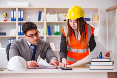 İnşaat ustabaşı çizimleri gözden geçiriyor